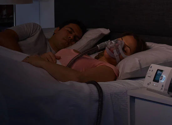 Mujer durmiendo con mascarilla AirTouch F20 ResMed en la noche